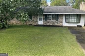 ranch-style home featuring a front yard, driveway, and a chimney