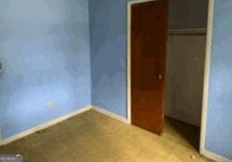 unfurnished bedroom with baseboards and a closet