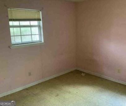 unfurnished room featuring light floors and baseboards