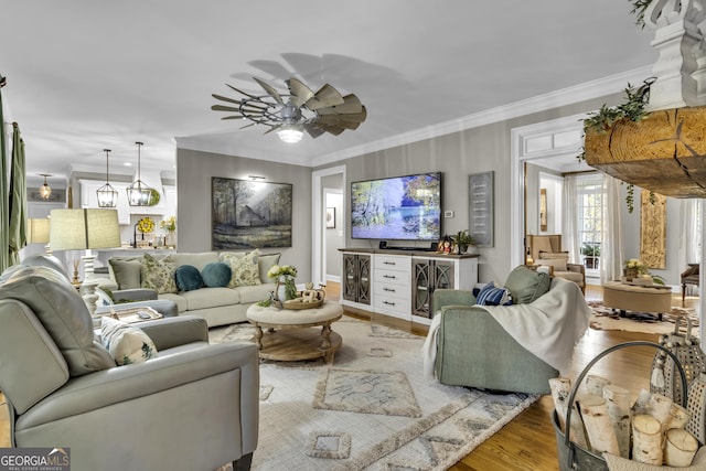 living area with ceiling fan, wood finished floors, and crown molding