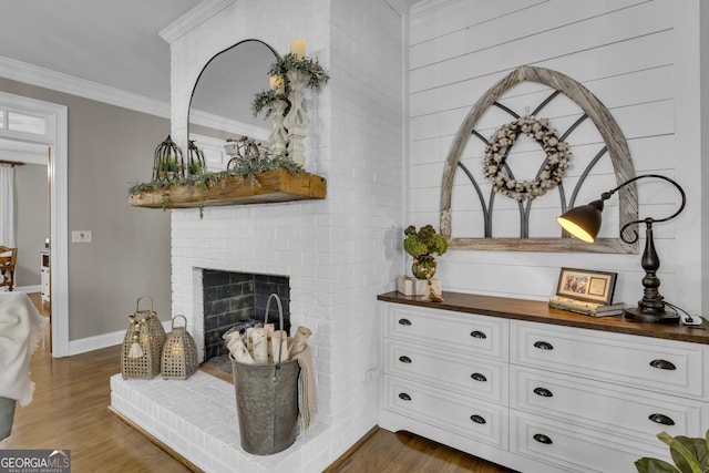 interior details with baseboards, a fireplace, wood finished floors, and crown molding