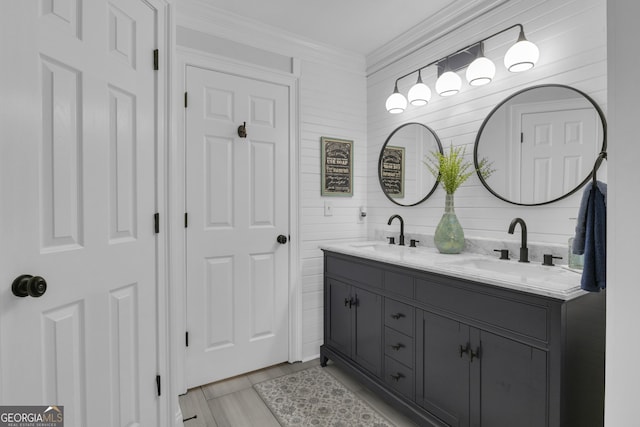 full bathroom with double vanity, crown molding, and a sink