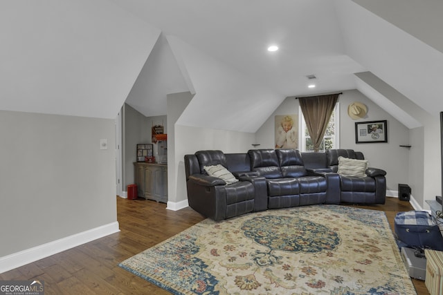 home theater room featuring vaulted ceiling, visible vents, baseboards, and wood finished floors