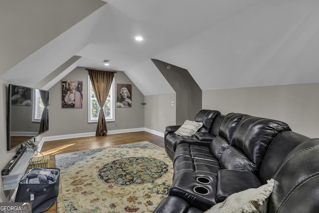 living area featuring lofted ceiling, wood finished floors, baseboards, and visible vents