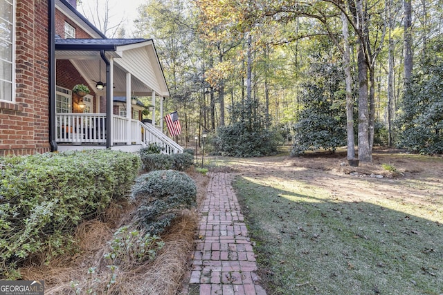 view of yard featuring covered porch and ceiling fan