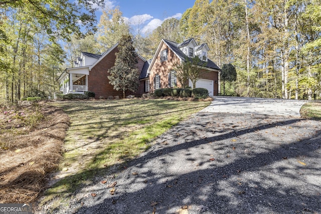 view of front of property featuring brick siding, a front yard, an attached garage, and driveway