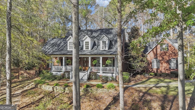 cape cod house with brick siding and a porch