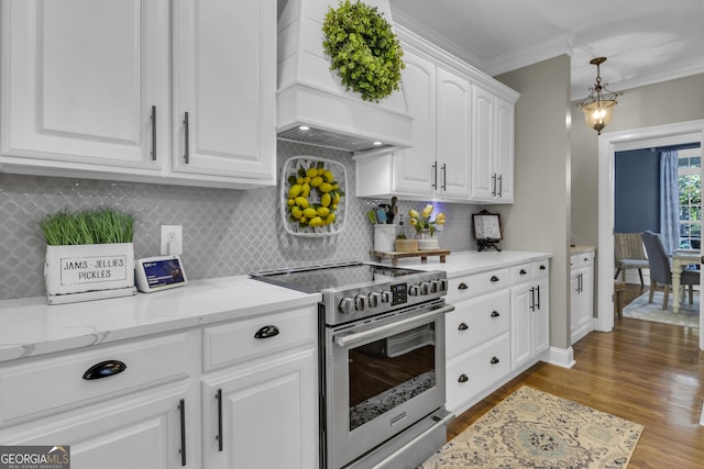 kitchen with crown molding, custom range hood, wood finished floors, electric range, and white cabinets