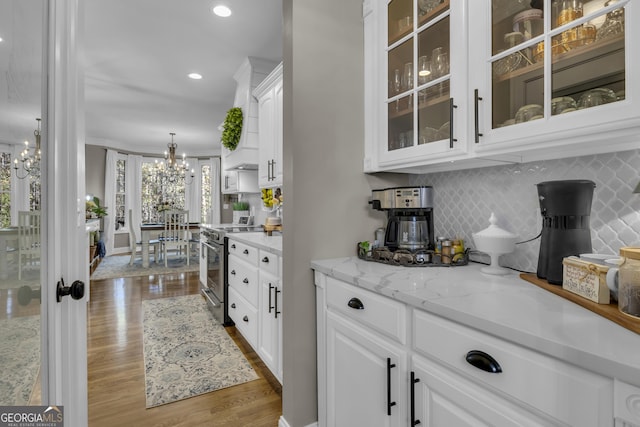 bar featuring tasteful backsplash, recessed lighting, electric stove, wood finished floors, and a notable chandelier