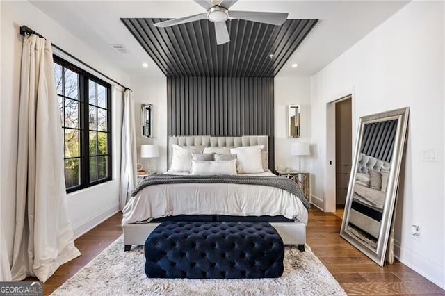 bedroom featuring a ceiling fan, baseboards, visible vents, and dark wood-type flooring