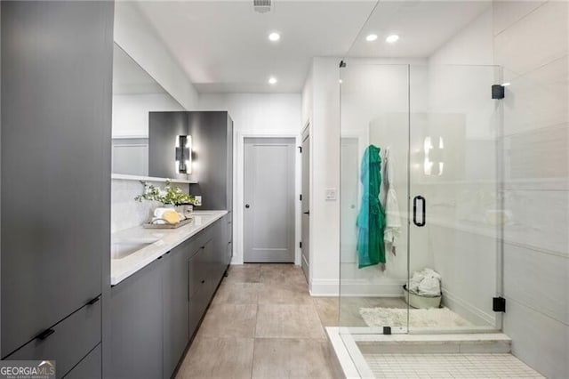 full bath with double vanity, recessed lighting, visible vents, a stall shower, and a sink