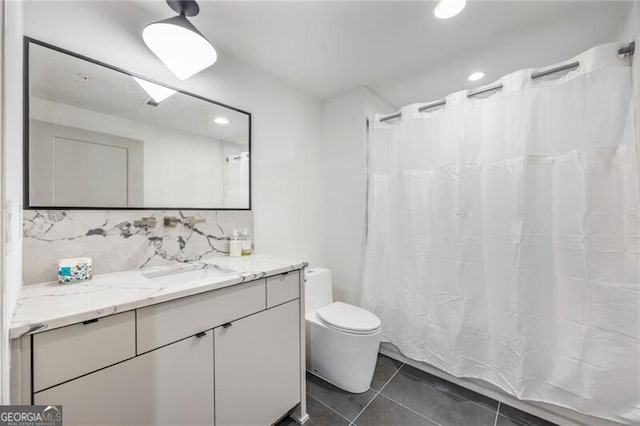 bathroom featuring toilet, tasteful backsplash, vanity, and tile patterned floors