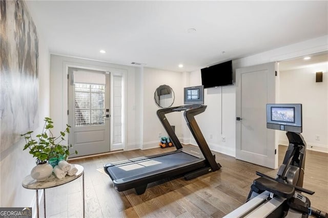 workout area featuring baseboards, wood finished floors, and recessed lighting