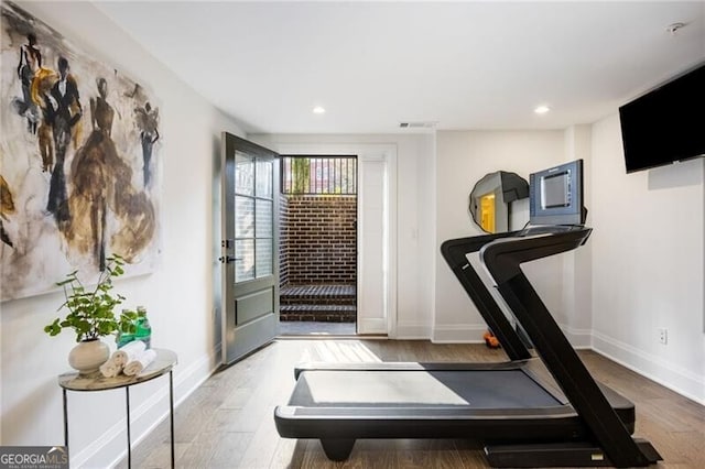 workout area with light wood-style floors, recessed lighting, and baseboards