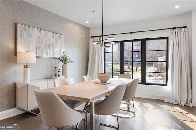 dining room with recessed lighting, wallpapered walls, baseboards, and wood finished floors