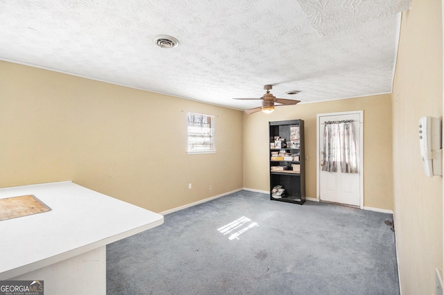 interior space featuring carpet floors, baseboards, visible vents, and a ceiling fan