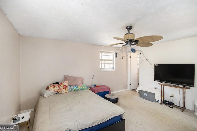 bedroom with ceiling fan, a textured ceiling, baseboards, and carpet flooring