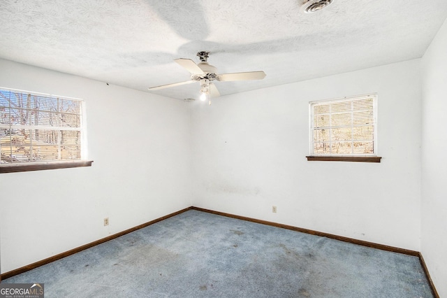 unfurnished room with a healthy amount of sunlight, ceiling fan, baseboards, and carpet flooring