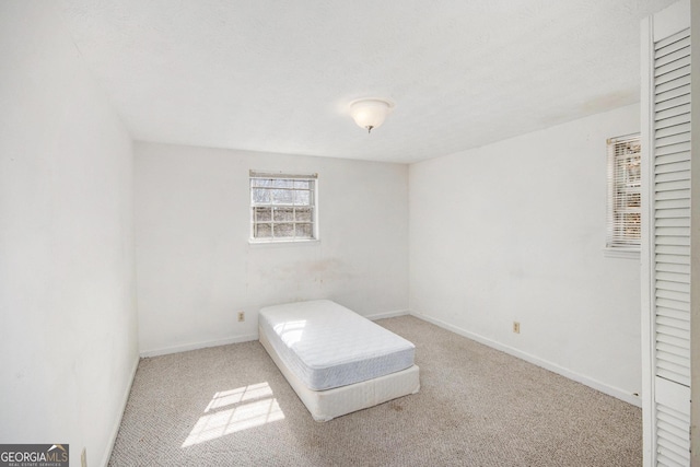 unfurnished bedroom featuring baseboards and carpet flooring