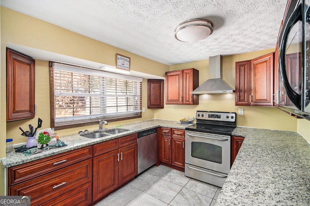 kitchen with light stone counters, stainless steel appliances, a textured ceiling, wall chimney range hood, and a sink