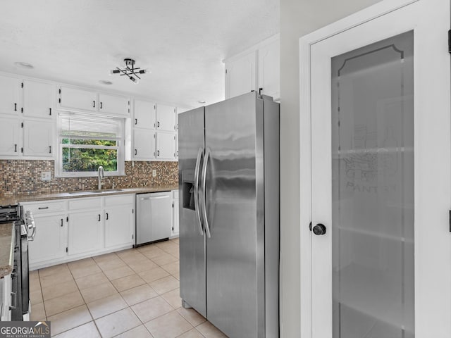 kitchen with backsplash, white cabinetry, stainless steel appliances, and a sink