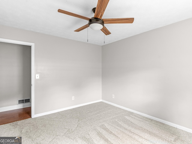 unfurnished room featuring baseboards, visible vents, ceiling fan, and carpet flooring