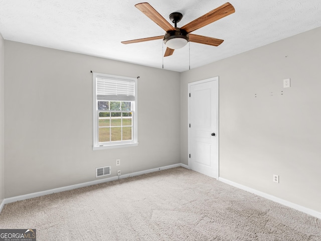 empty room featuring baseboards, visible vents, ceiling fan, a textured ceiling, and carpet flooring