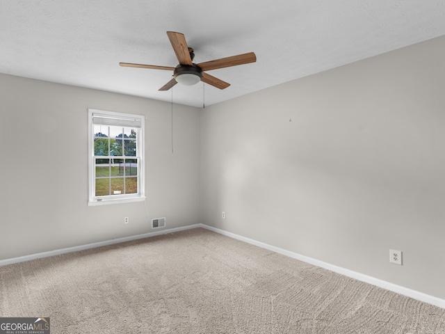 carpeted empty room with baseboards, visible vents, ceiling fan, and a textured ceiling