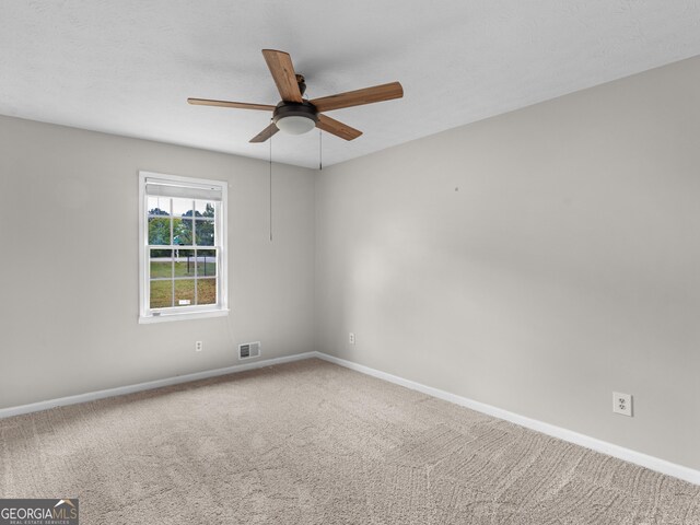 empty room featuring ceiling fan, carpet, and baseboards