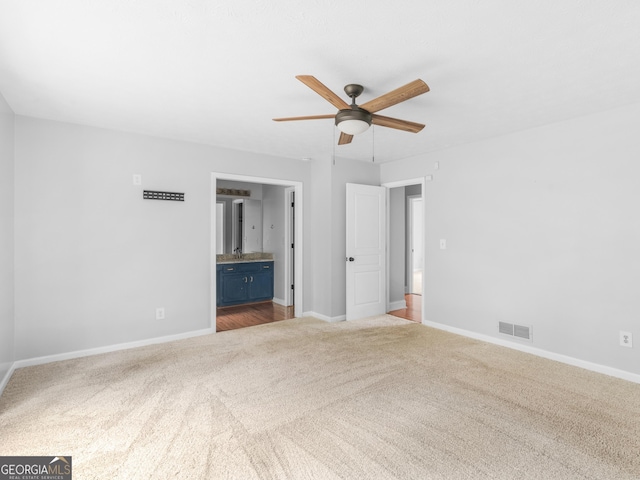 unfurnished bedroom with carpet floors, visible vents, ceiling fan, ensuite bath, and baseboards