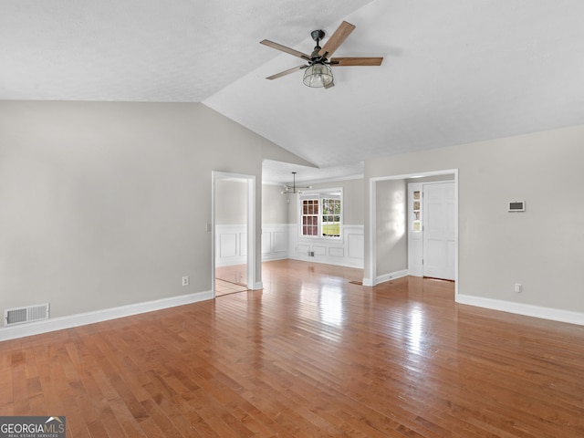 unfurnished living room featuring light wood-style floors, vaulted ceiling, visible vents, and ceiling fan