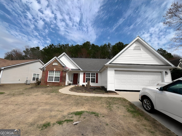 ranch-style house featuring concrete driveway, brick siding, an attached garage, and central AC unit