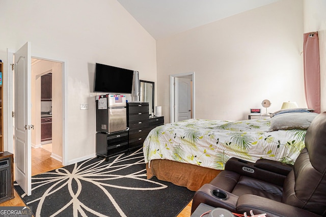 bedroom featuring baseboards, high vaulted ceiling, and wood finished floors