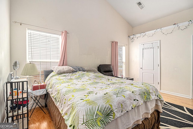 bedroom with multiple windows, wood finished floors, and visible vents