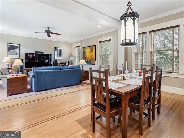 dining room with ceiling fan, ornamental molding, light wood-type flooring, and baseboards