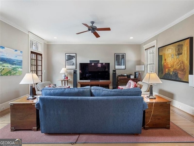 living area with ornamental molding, wood finished floors, and baseboards