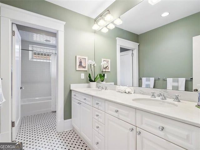 full bath with double vanity, shower / bath combo, a sink, and baseboards