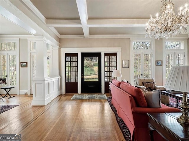 foyer entrance featuring beam ceiling, french doors, light wood finished floors, a healthy amount of sunlight, and coffered ceiling