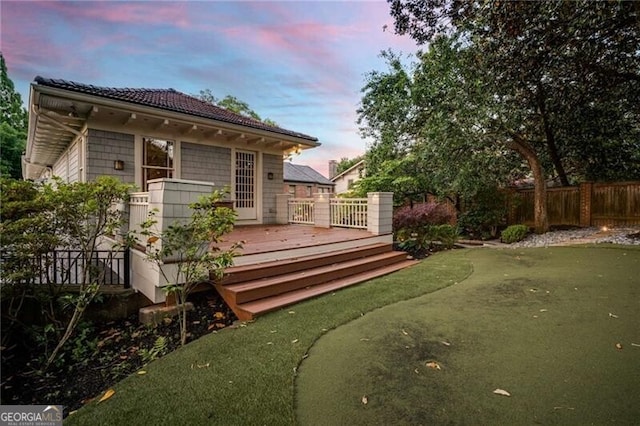 back of house featuring fence and a wooden deck