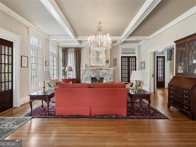 living room featuring a stone fireplace, coffered ceiling, wood finished floors, and beam ceiling