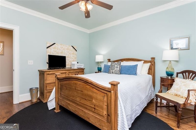 bedroom featuring ceiling fan, crown molding, baseboards, and wood finished floors