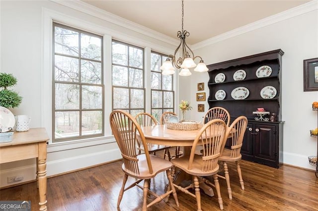 dining space with crown molding, baseboards, a chandelier, and wood finished floors