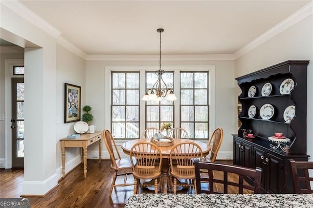 dining area with an inviting chandelier, dark wood-style flooring, baseboards, and crown molding