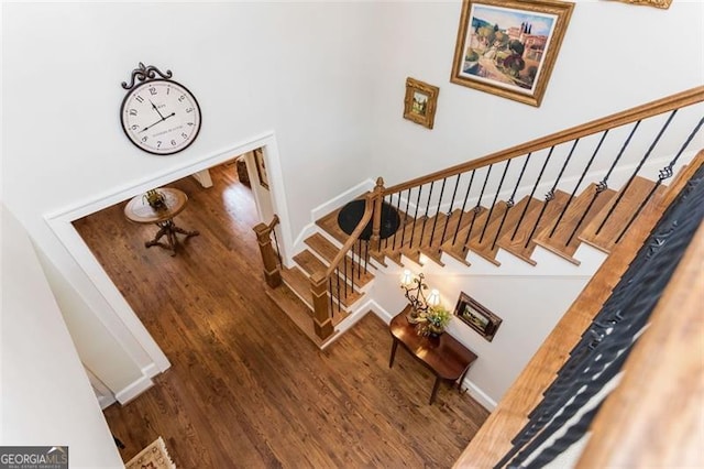 staircase with baseboards and wood finished floors