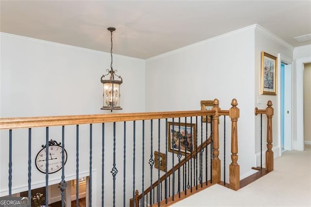 hall with baseboards, carpet flooring, an upstairs landing, crown molding, and visible vents