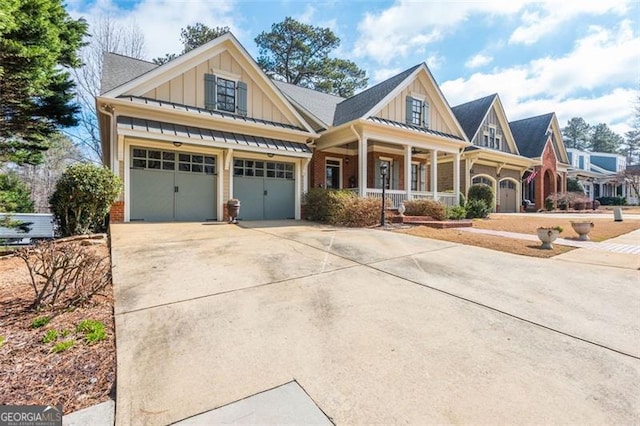 craftsman-style house featuring covered porch, concrete driveway, board and batten siding, and a standing seam roof