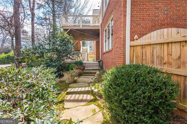 view of property exterior with fence and brick siding