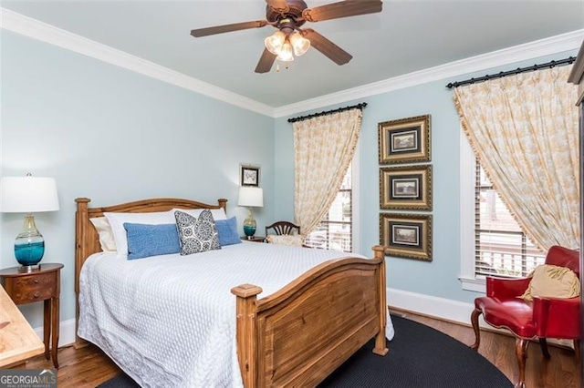 bedroom with baseboards, multiple windows, ornamental molding, and wood finished floors