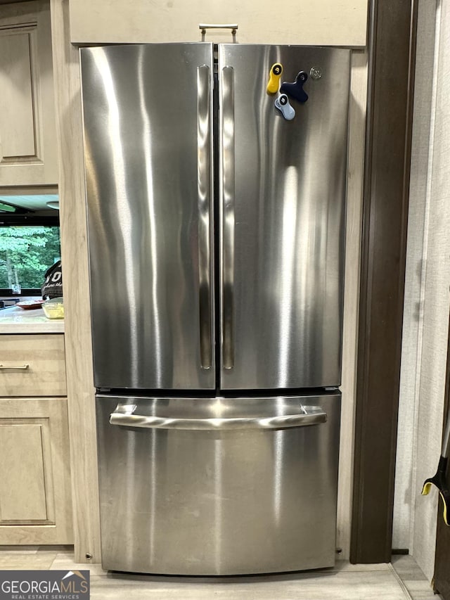 room details featuring freestanding refrigerator, light countertops, and light brown cabinetry