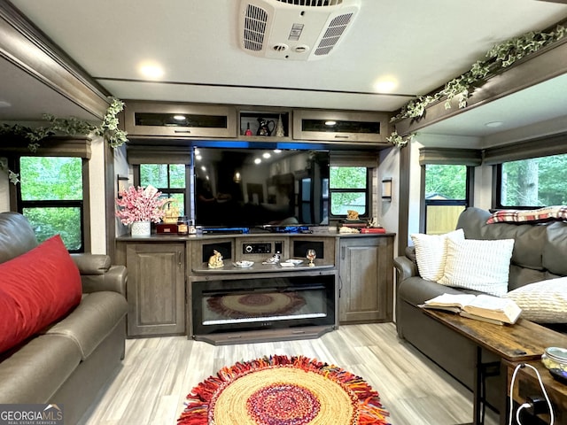 living area featuring light wood-style flooring and visible vents